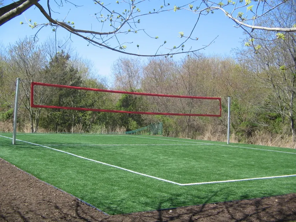 Outdoor artificial grass volleyball court in a park setting