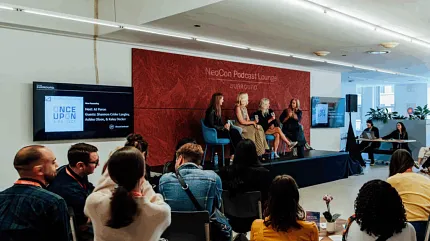 Engaging panel event at NeoCon Podcast Lounge NeoCon Podcast Lounge with diverse audience and panel discussion