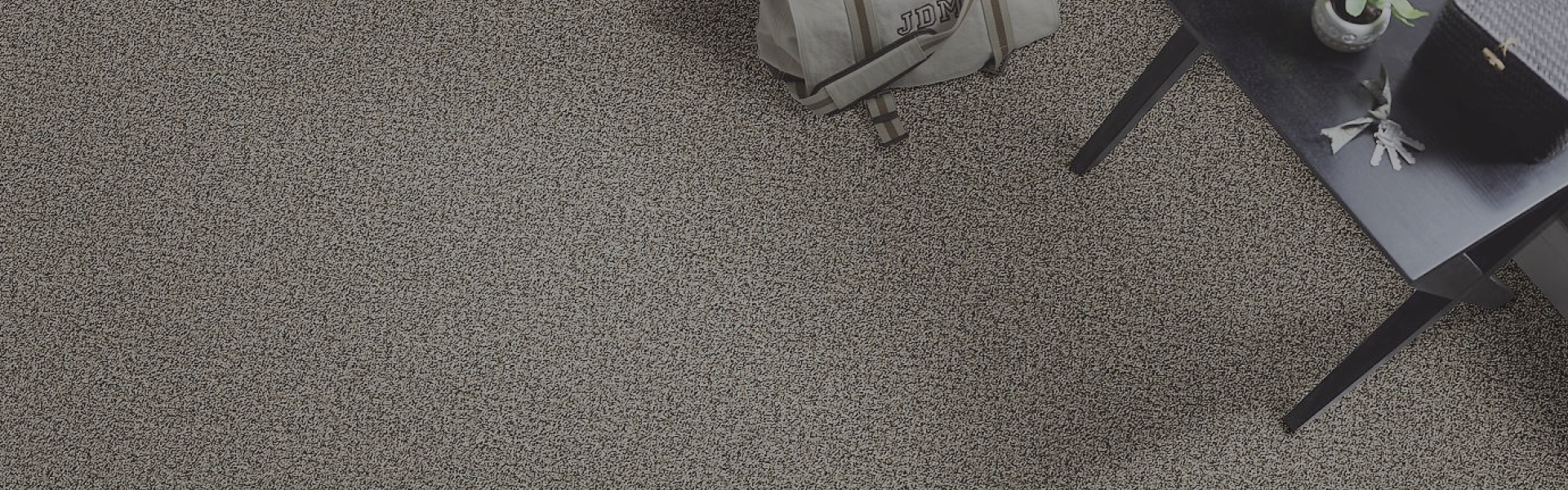 Carpet flooring with a bag and short desk on the side.