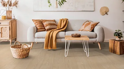 Light Wood Laminate Flooring in a Cozy Living Room Setting Cozy living room with light wood laminate flooring, a gray sofa adorned with orange and brown pillows, and a woven basket on the floor