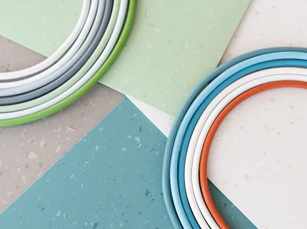 Commercial Heterogeneous Sheet Vinyl Flooring Swatch in Multiple Colors Swatch of commercial heterogeneous sheet vinyl flooring in green, blue, beige, and gray colors with circular color samples