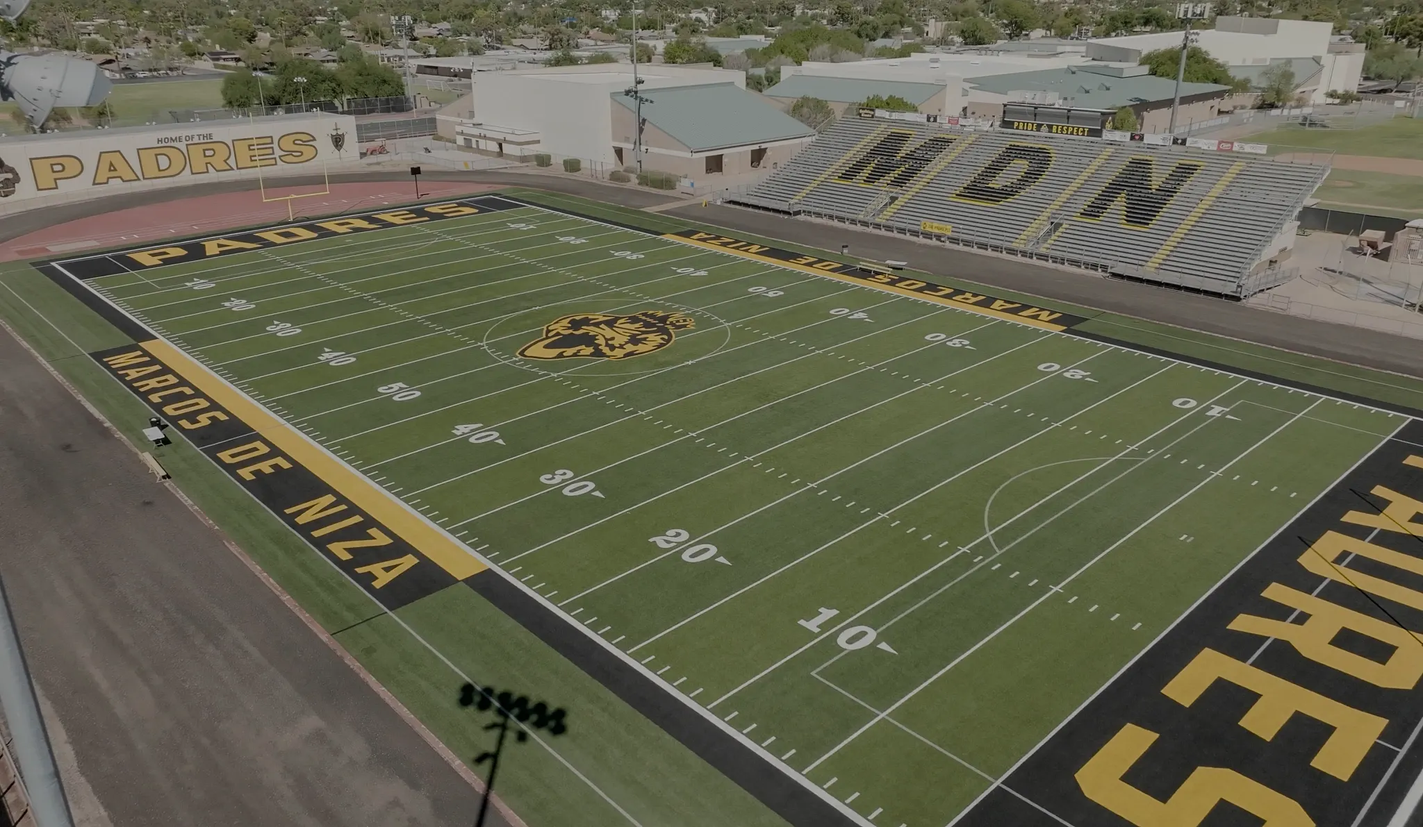 Aerial view of a high school football field with bleachers