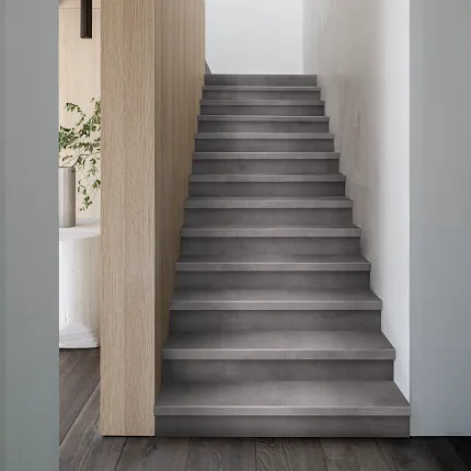Gray Luxury Vinyl Tile Flooring on Modern Staircase in Minimalist Interior Modern staircase with gray luxury vinyl tile flooring in a minimalist interior setting
