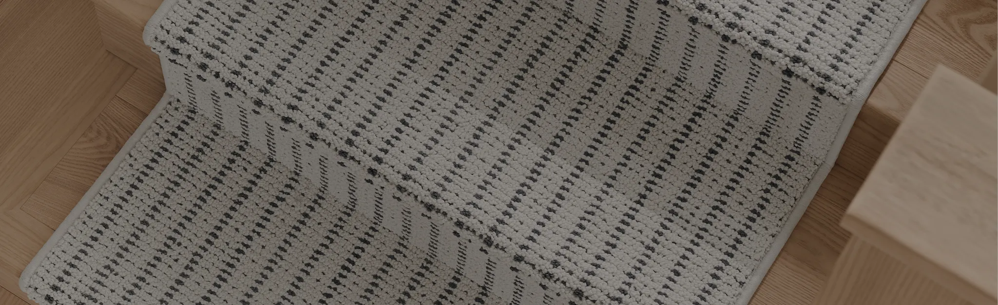 Beige and brown herringbone pattern carpet with hardwood flooring and sandals