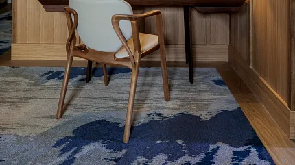 Stylish workspace with warm wood tones and artistic carpet design Cozy study area with wooden paneling and patterned carpet