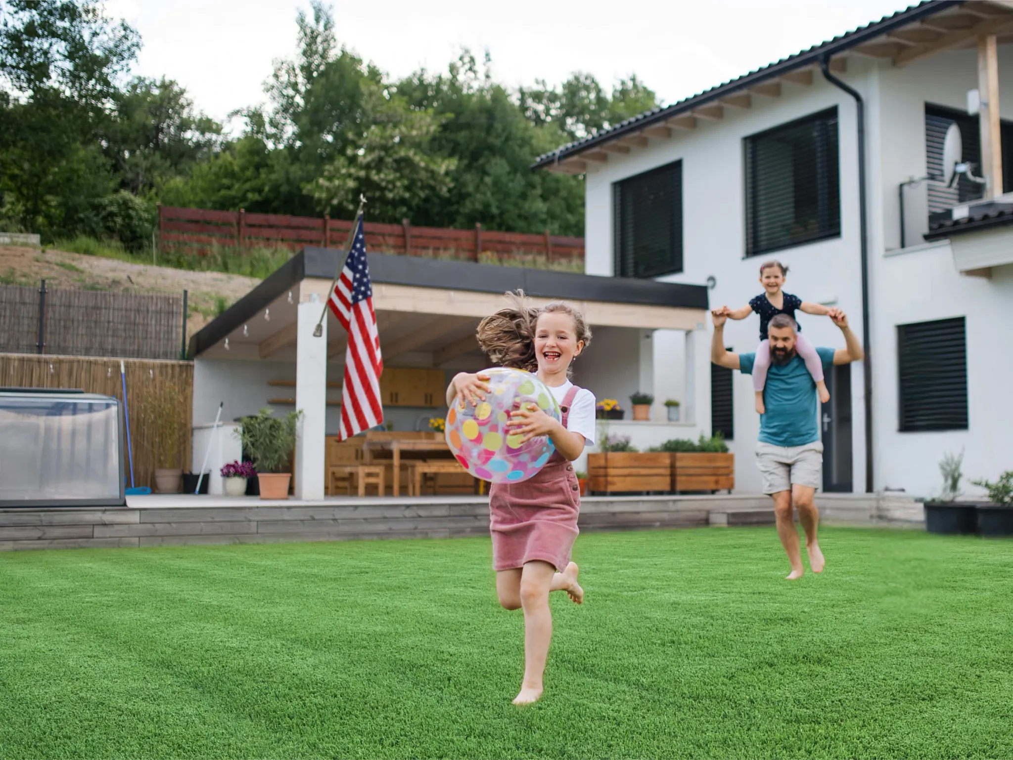 Family playing on lush green lawn in backyard