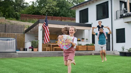 Enjoy outdoor fun on vibrant grass lawn Family playing on lush green lawn in backyard