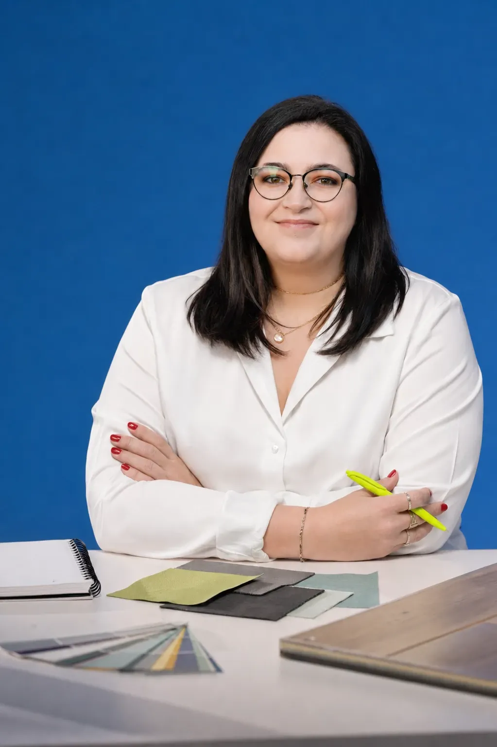 Woman in a pink top and checkered blazer sitting in a room with light-colored furniture