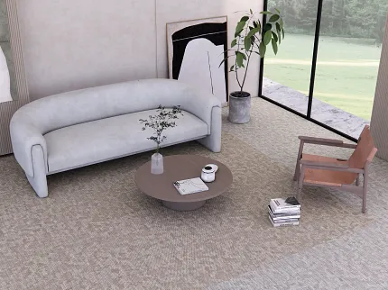 Terra Tile from the Core Elements Collection in Commercial Lounge Setting | Shaw Contract Australia Terra Tile carpet tile from the Core Elements collection by Shaw Contract installed in a contemporary commercial lounge featuring a curved sofa, timber lounge chair, round coffee table and floor-to-ceiling windows with views of landscaped greenery.