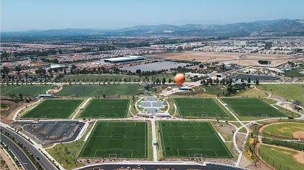 Aerial View of Artificial Turf Soccer Fields in Sports Complex Aerial view of multiple artificial turf soccer fields in a large sports complex with surrounding landscape and parking area