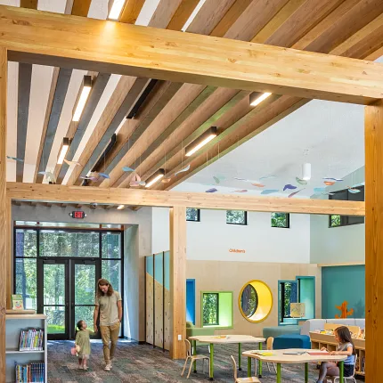 Education Facility with Commercial Carpet Tile Flooring in Gray and Teal Education facility with commercial carpet tile flooring in shades of gray and teal, featuring wooden beams and colorful children's area with tables and chairs