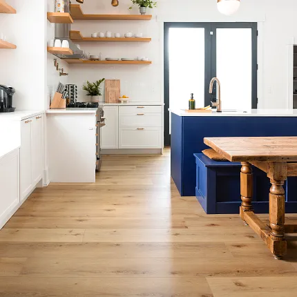 Contemporary kitchen design with light wood flooring and blue accents Modern kitchen with light wood flooring, white cabinets, and blue island