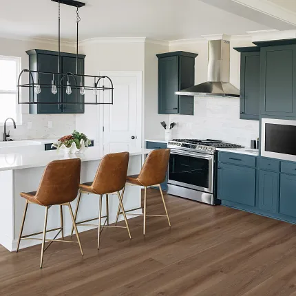 Stylish kitchen with durable hardwood flooring and contemporary design elements Modern kitchen with brown hardwood flooring, navy cabinets, and brown leather bar stools