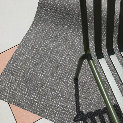 Gray Patterned Carpet with Textured Design Next to Green Chair Gray patterned carpet with a textured design next to a green metal chair on a tiled floor