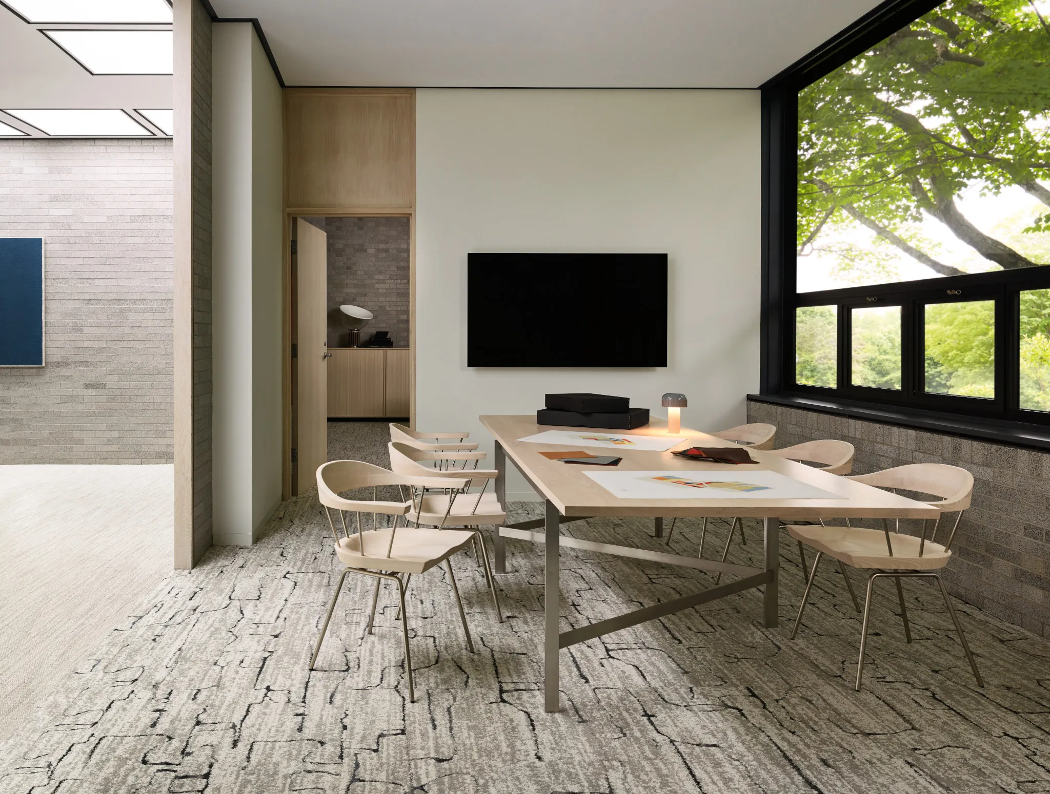 Modern meeting room with large window and textured carpet flooring