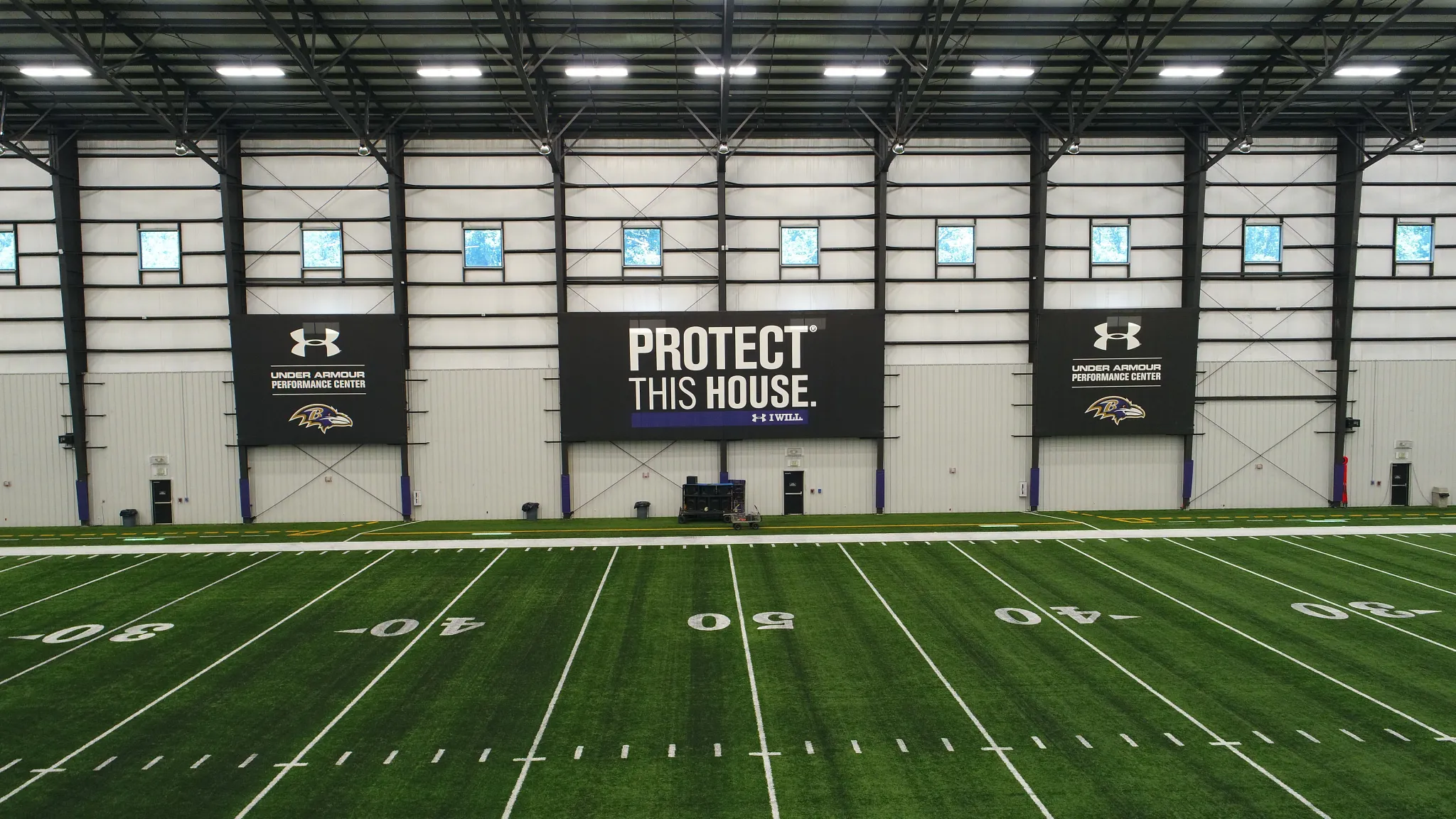 Indoor sports facility with artificial turf field and Under Armour branding