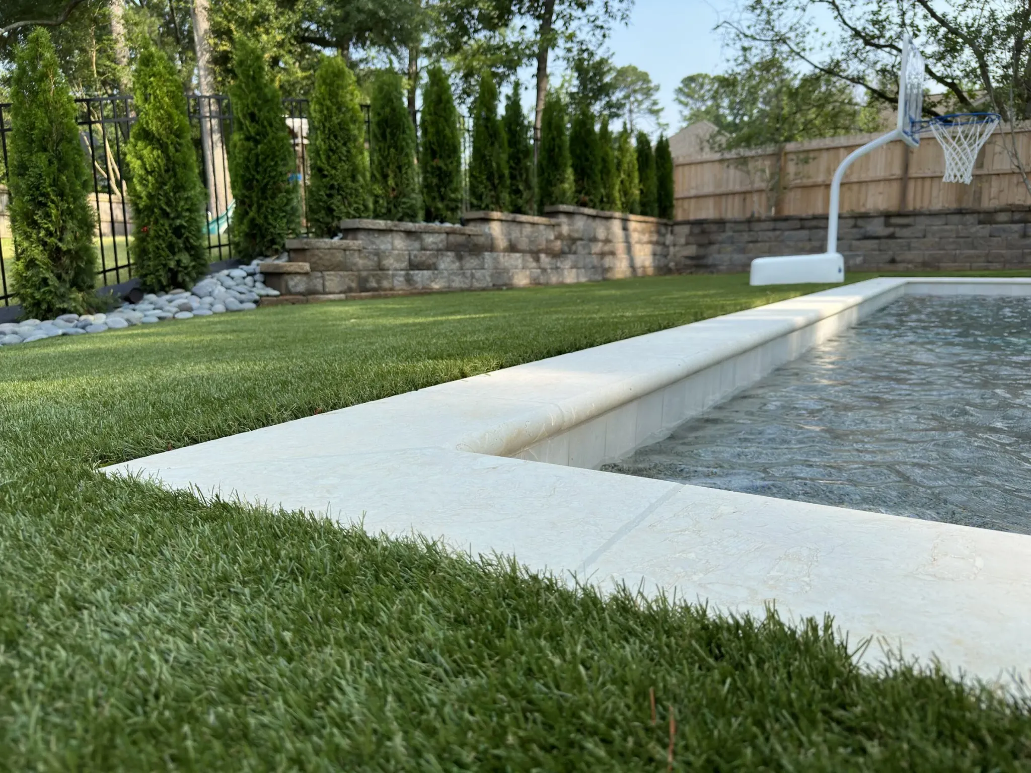 Artificial grass surrounding a backyard pool area