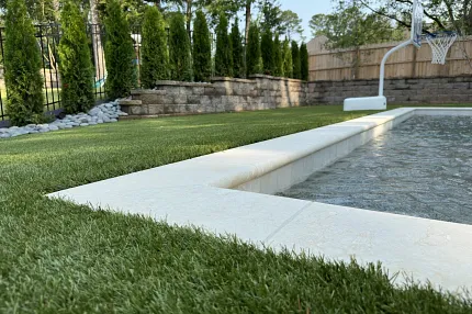 Premium synthetic turf for outdoor landscapes Artificial grass surrounding a backyard pool area