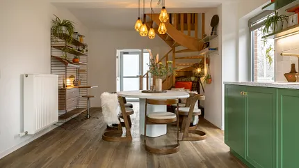 Wood Look Luxury Vinyl Plank Flooring in Modern Dining Room Scene Modern dining room with wood look luxury vinyl plank flooring, featuring a round table and chairs, green cabinetry, and a spiral staircase.