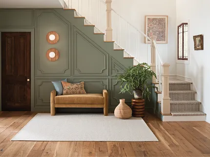 Premium Hardwood Flooring in Stylish Living Room Decor Elegant living room with natural hardwood flooring and a beige area rug