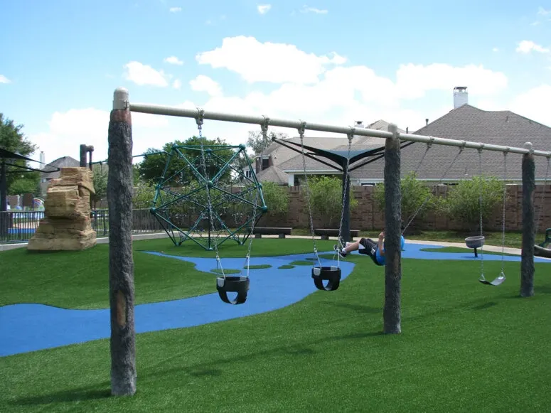 Playground with swings and artificial grass