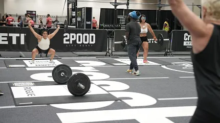 Durable flooring for high-performance gym environments Indoor gym scene with athletes lifting weights on branded flooring