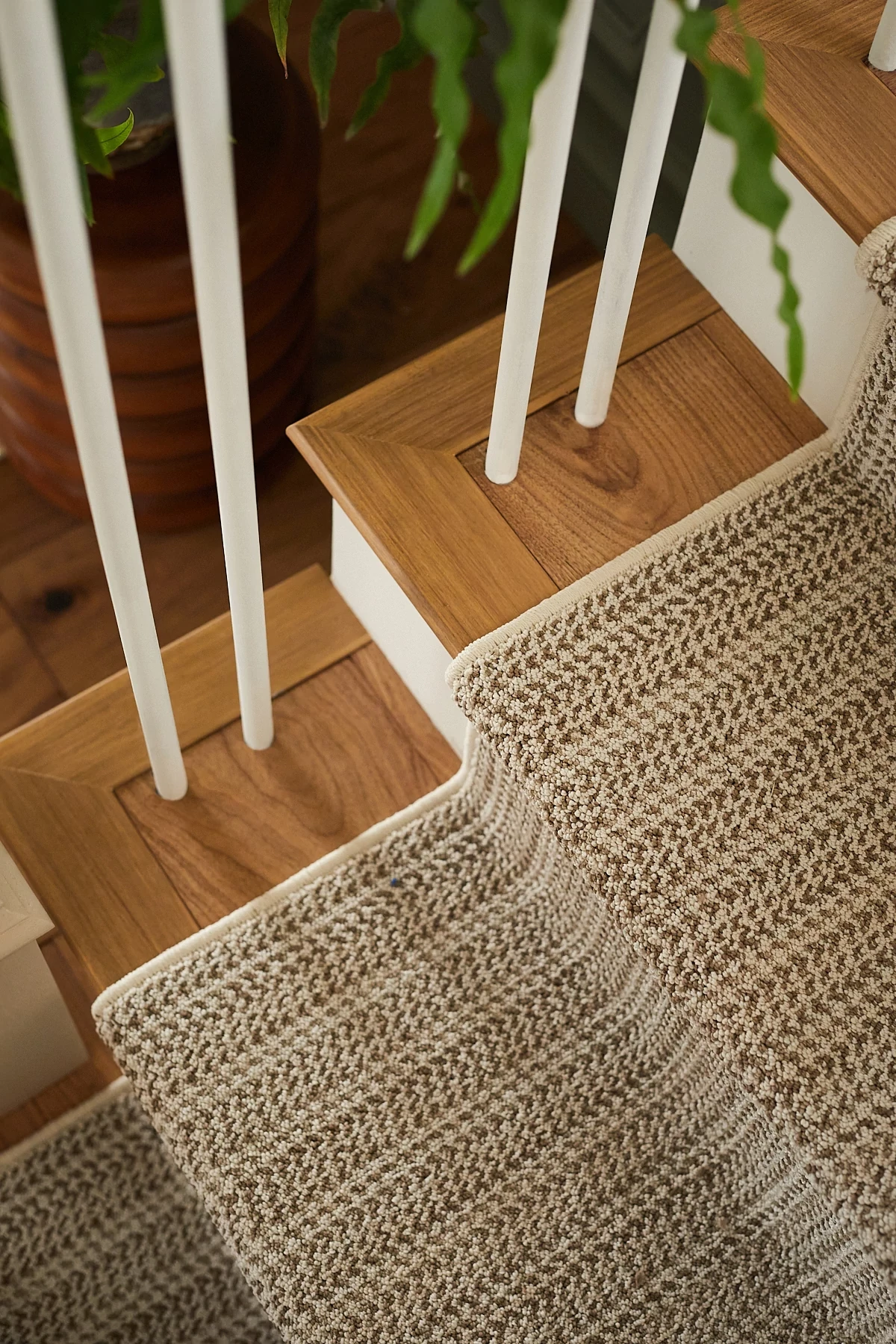 Linear patterned stair runner in a beige color on natural wood staircase