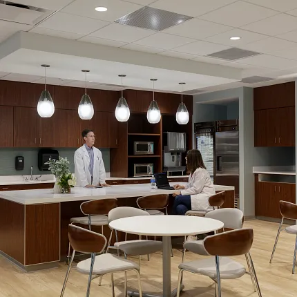 Healthcare Facility Break Room with Light Wood Flooring and Modern Design Healthcare Facility break room with wooden cabinetry, modern lighting, and light wood flooring