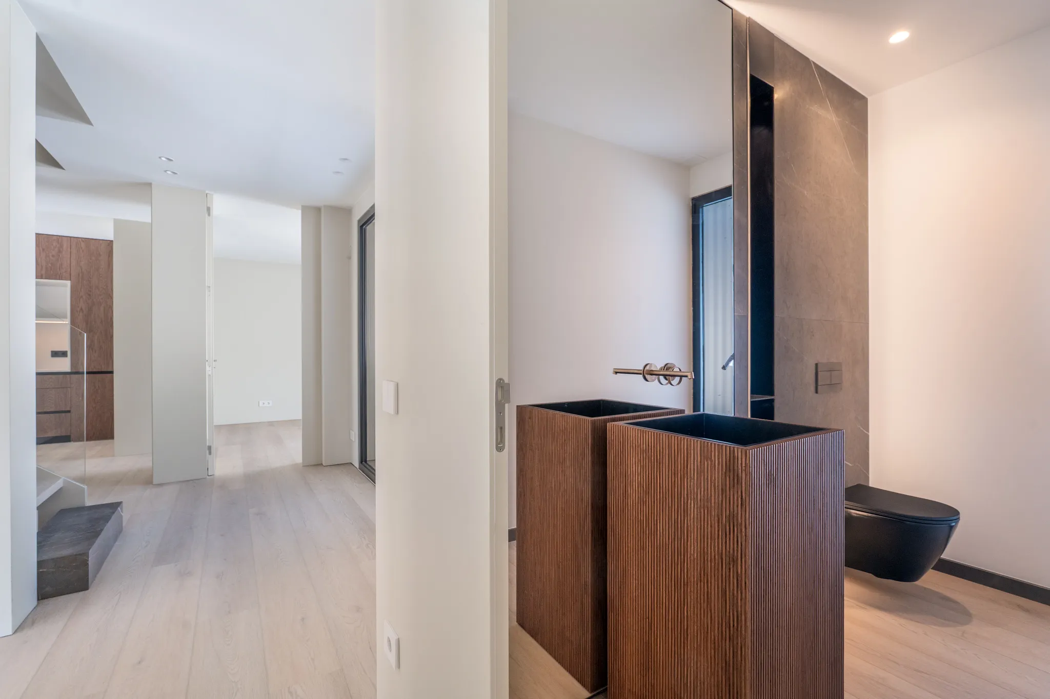 Modern bathroom and bedroom with walnut cabinets and light wooden Coretec floor