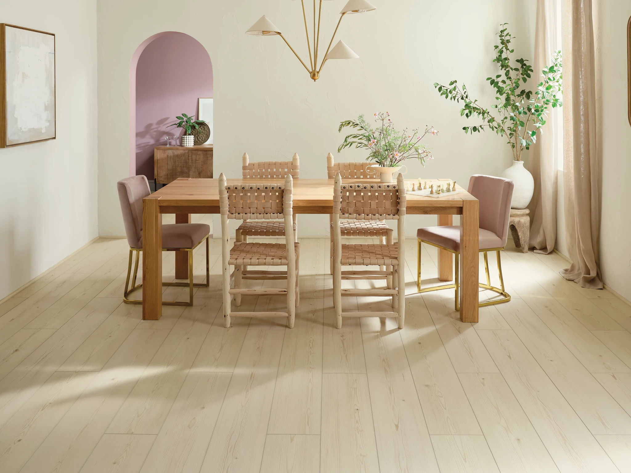 dining room with light wood look luxury vinyl plank floor with a wooden table and chairs and soft pink accents