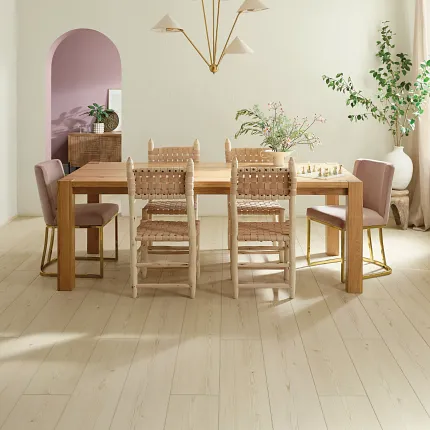 Light Wood Look Luxury Vinyl Plank Flooring in Modern Dining Room Scene dining room with light wood look luxury vinyl plank floor with a wooden table and chairs and soft pink accents