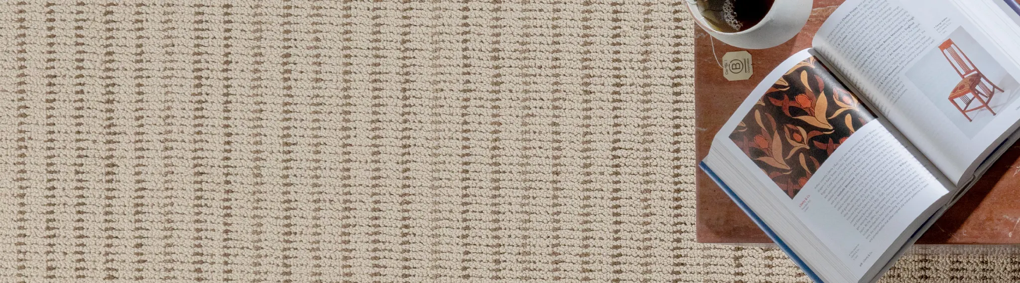 Beige textured carpet with open book and coffee cup on table