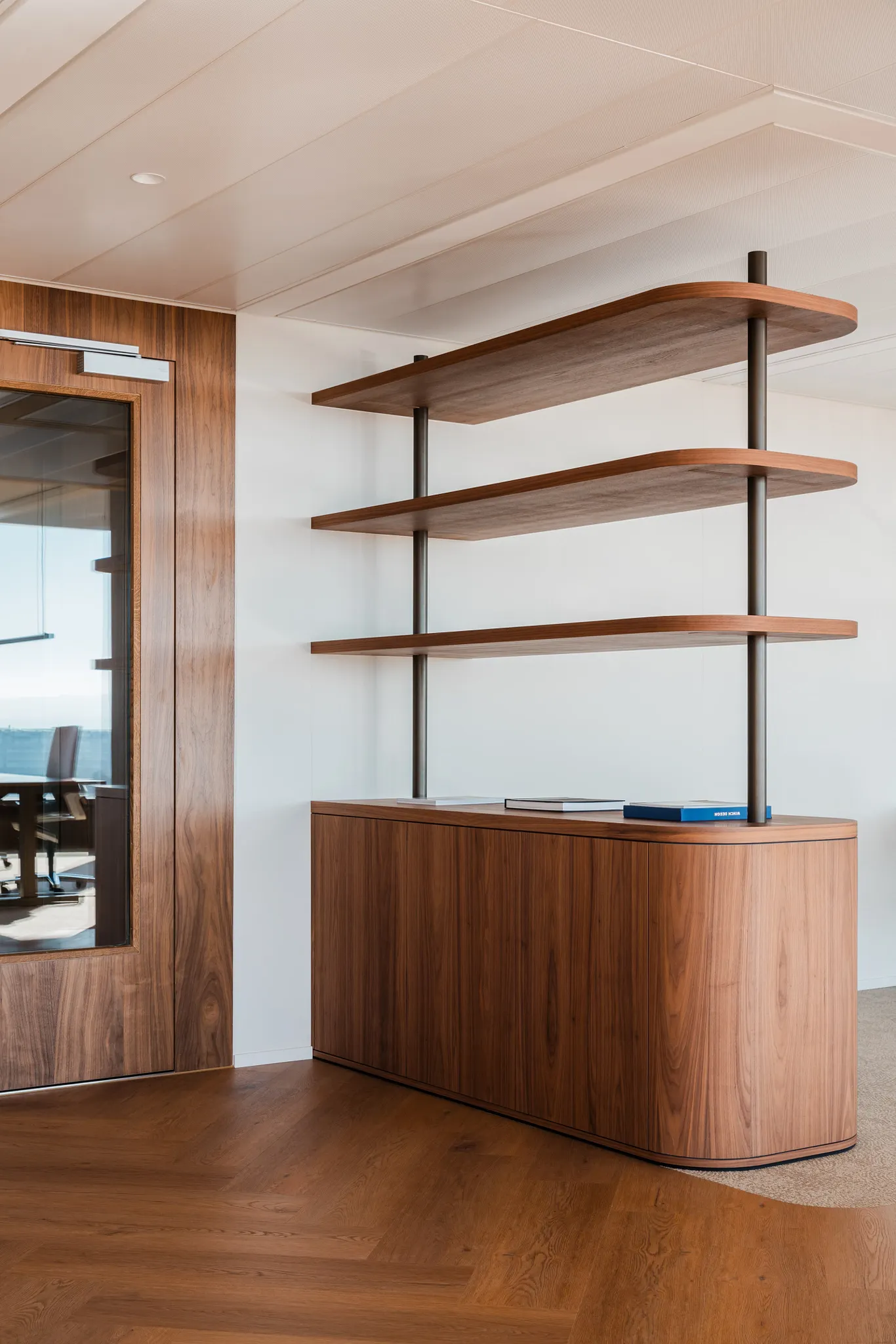 Office with wood herringbone Coretec floors in rich tones and wooden storage room