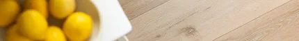 Light Wood Look LVP Flooring - 72.83x9.06 inch - Coretec Residential SPC Light wood look luxury vinyl plank flooring with lemons on a white table