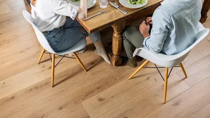 Coretec Residential SPC Luxury Vinyl Plank Flooring - Natural Wood Look, 72.83x9.06 inch Dining room scene with young couple enjoying a meal on Coretec Residential SPC luxury vinyl plank flooring in a natural wood look, 72.83x9.06 inch dimensions