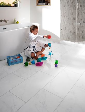A boy playing with toys in a bathroom on a luxury vinyl floor