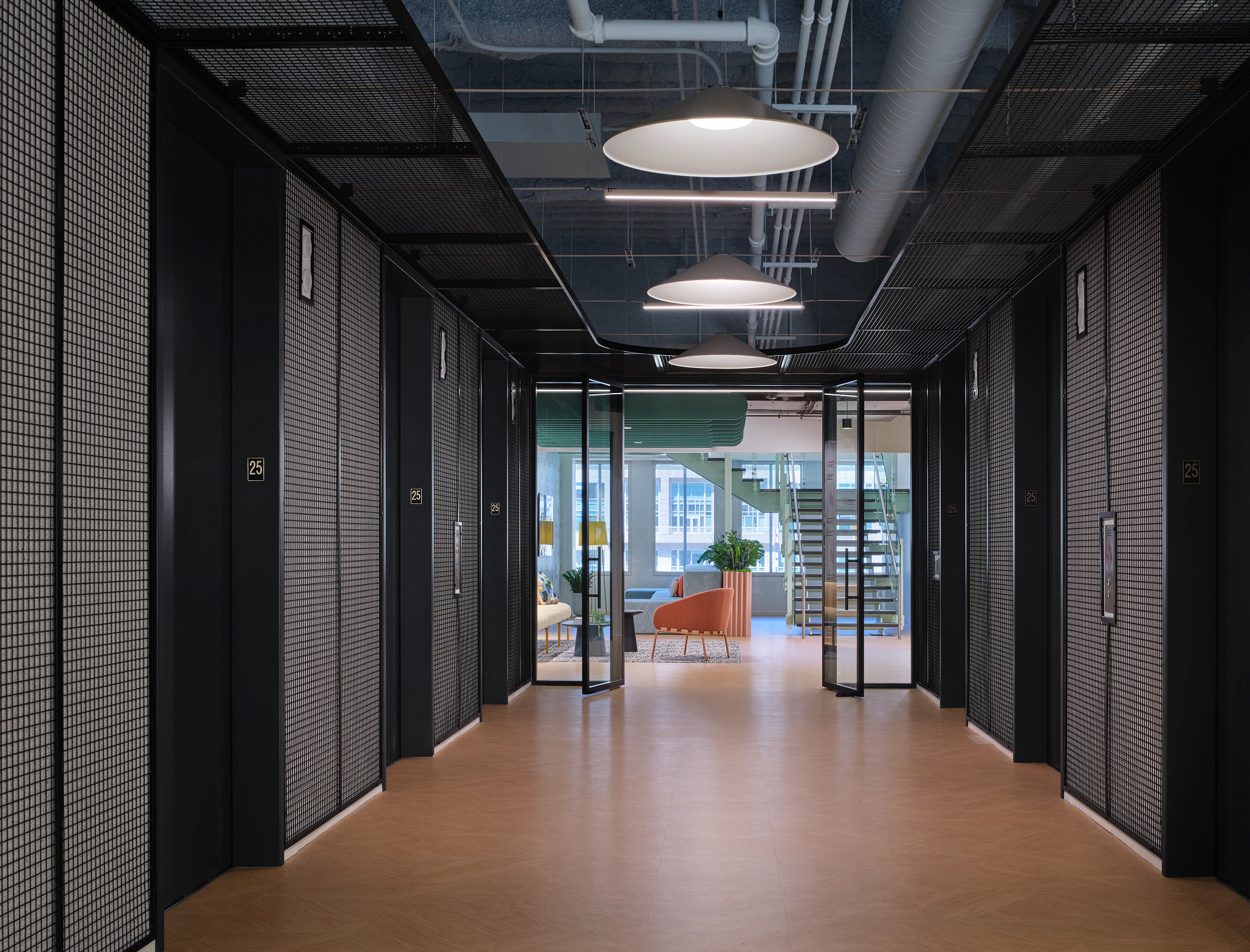 Modern workplace hallway with heavy commercial luxury vinyl tile flooring in 18x18 inch dimensions, featuring black elevator doors and contemporary lighting.