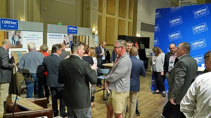 COREtec Flooring Trade Show Event with Luxury Vinyl Display Group of people at a flooring trade show with COREtec branding and luxury vinyl flooring display