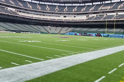 Artificial Turf Football Field in Stadium Artificial turf football field in a large stadium with empty seating