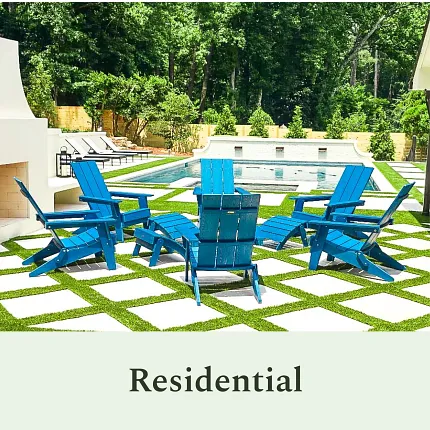 Stylish residential outdoor seating area with pool Outdoor patio with blue chairs and checkerboard grass tiles