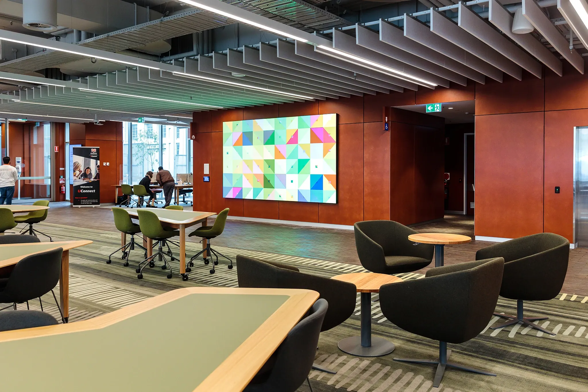 Collaborative learning space at the University of Tasmania featuring custom patterned carpet flooring, flexible study areas and contemporary educational interiors.