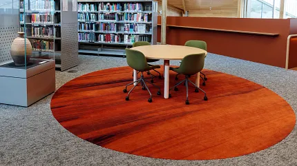 University of Tasmania Library Featuring Custom Flooring Design | Shaw Contract Custom circular flooring installation within the University of Tasmania library, featuring rich earthy tones inspired by Indigenous storytelling and collaborative study spaces.