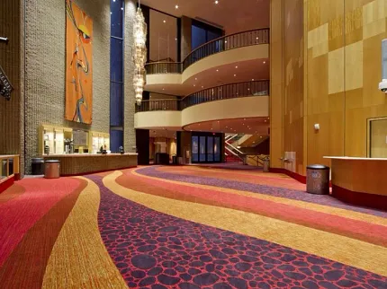 Vibrant Commercial Broadloom Carpet in Hospitality Facility Lobby Luxurious hospitality facility lobby with vibrant red, orange, and purple commercial broadloom carpet featuring abstract patterns