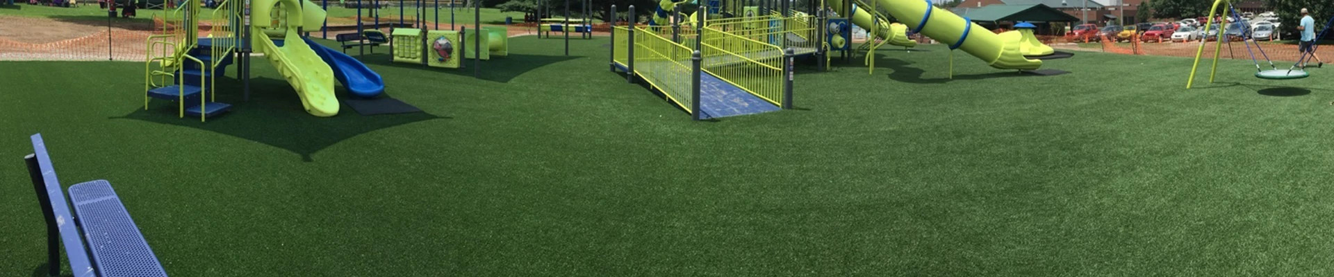 Playground with green artificial turf and yellow play structures