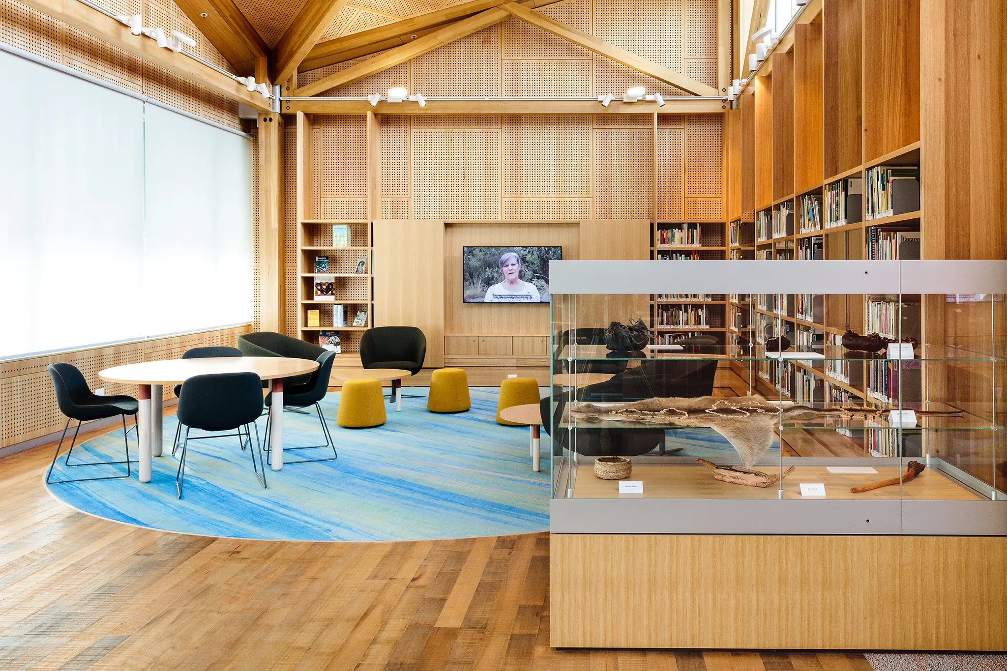 University of Tasmania library learning space featuring custom blue patterned flooring, collaborative seating and a cultural display showcasing local artefacts.