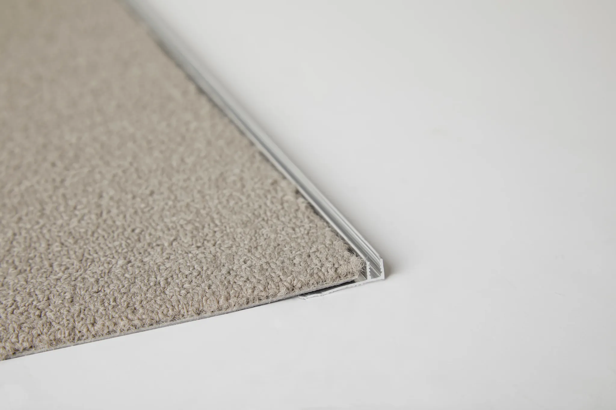 Beige commercial carpet tile swatch with visible edge detail