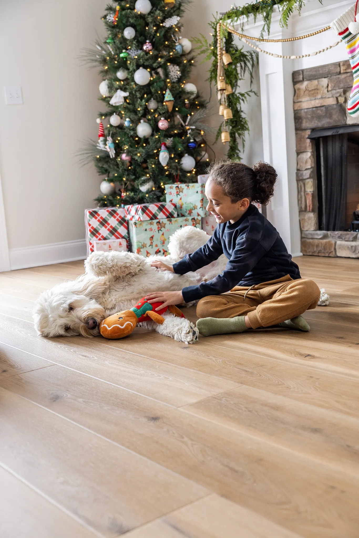 Cozy holiday scene with a child and dog on wood look luxury vinyl plank flooring