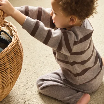 Cozy and Durable Beige Patterned Carpet for Everyday Comfort Child sitting on soft beige patterned carpet with a wicker basket