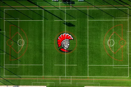 Artificial Turf Sports Field with Spartan Logo Aerial view of a sports field with artificial turf featuring a red and black Spartan logo in the center