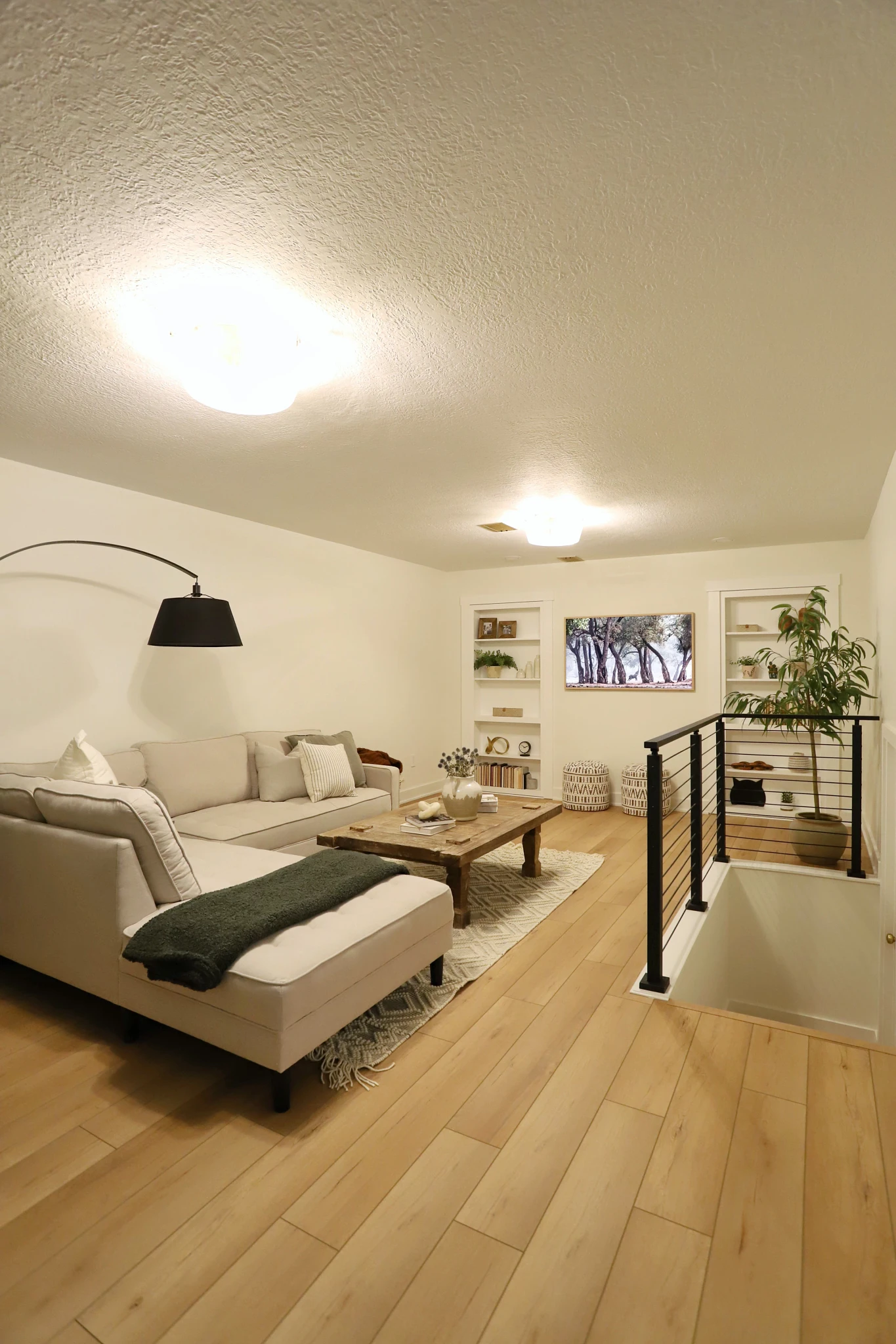 Modern living room with beige sectional sofa and wood look luxury vinyl plank flooring